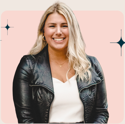 A smiling woman with blonde hair wearing a black leather jacket and a white top against a pink background with star accents.
