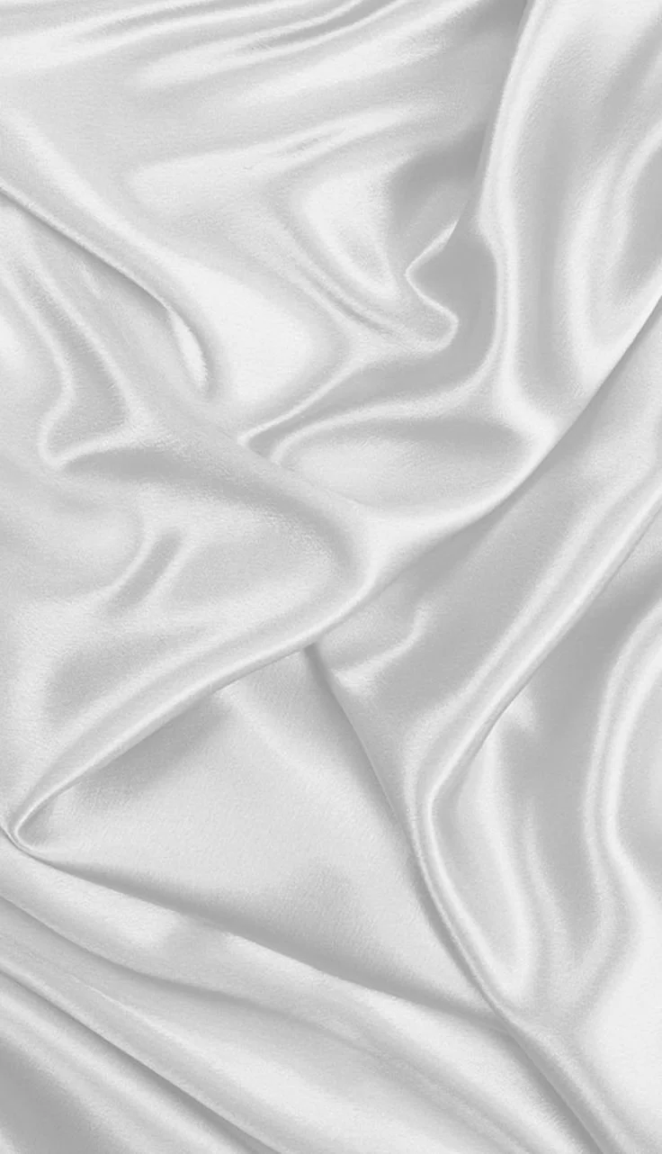 Close-up of smooth, white satin fabric with gentle folds and sheen.