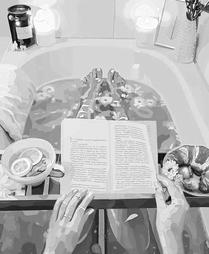 A person soaking in a bathtub filled with water, with their hands clasped together. On the bathtub's edge, there's a book open, a bowl of sliced lemons, and a bowl of decorated eggs. In the background, there is a bottle of soap or shampoo, a candle, a plant, and a framed picture.