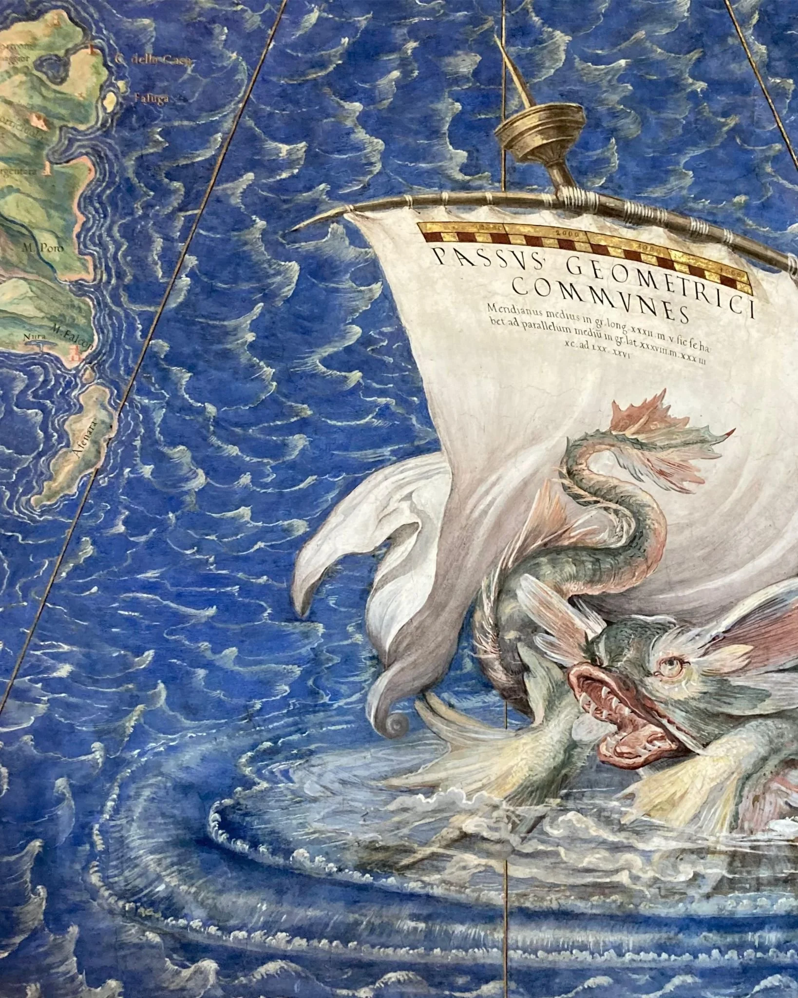 Une carte ancienne représentant une mer avec une bête mythologique semblable à un dragon ou à un serpent marin coiffé d'une voile avec des textes en latin.