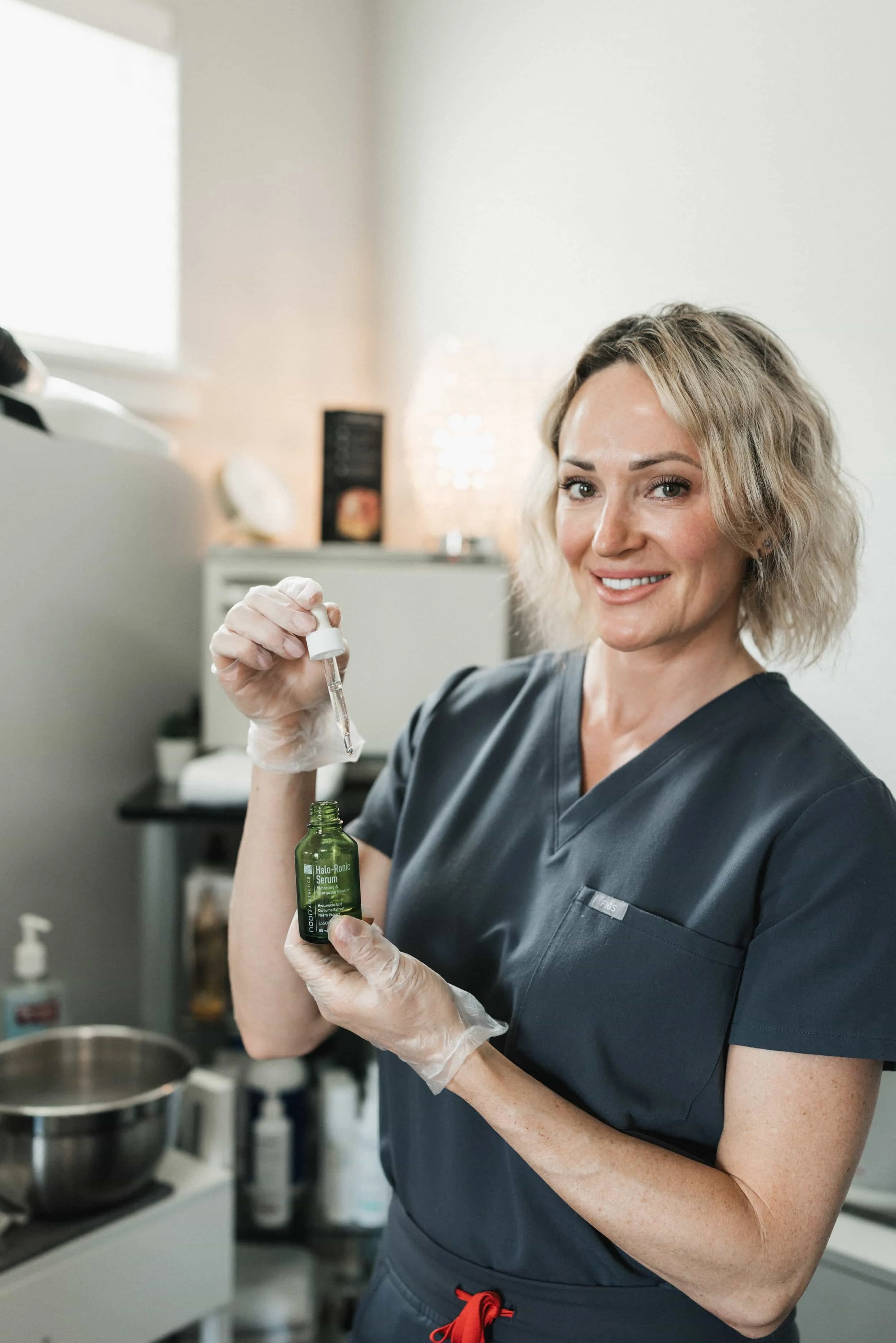 esthetician holding skincare product for anti-aging treatments in Vancouver, WA