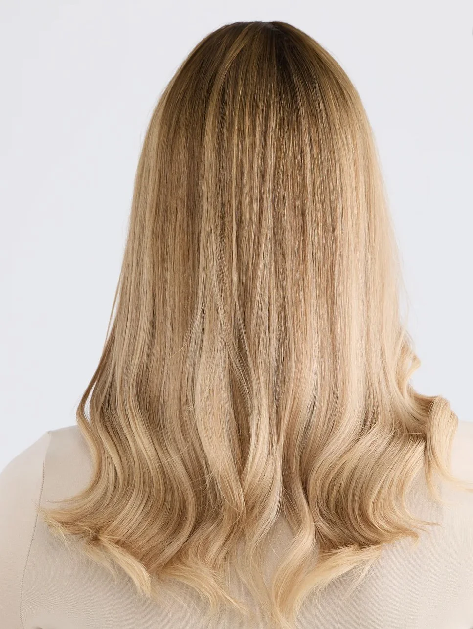 Back view of a woman with long, blonde, wavy hair.