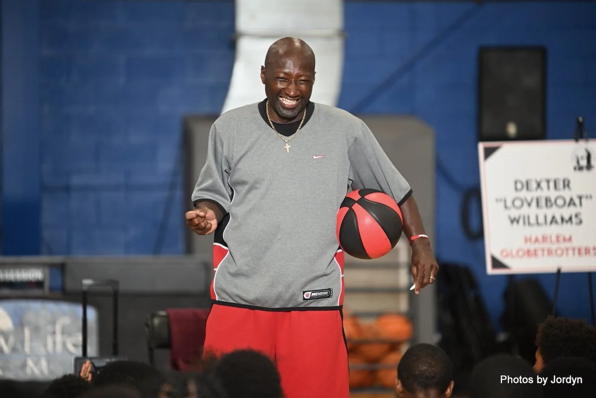 Inspirational speaker Dexter Williams holding a basketball while addressing a youth camp