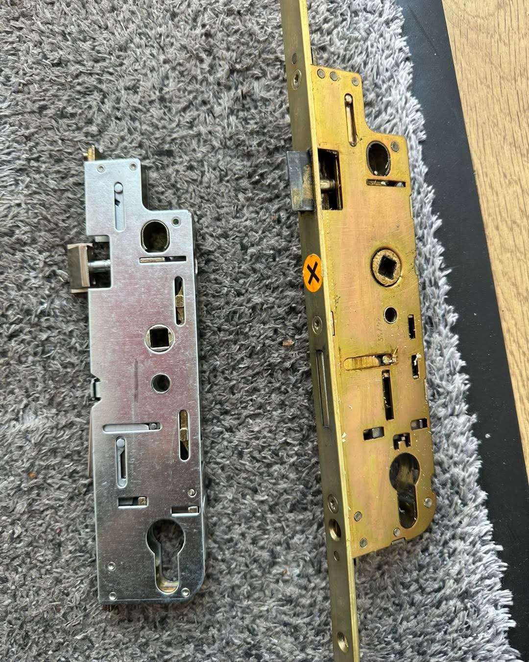 Replacement uPVC door lock mechanism shown alongside the old faulty gearbox during a repair in Kensington.