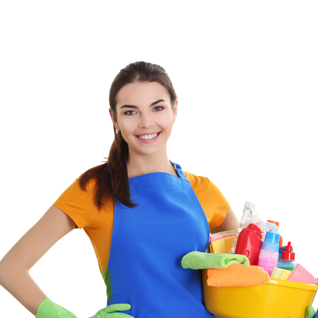 Young woman smiling while holding a yellow cleaning caddy filled with spray bottles, sponges, and cleaning supplies, wearing a blue apron and green gloves.