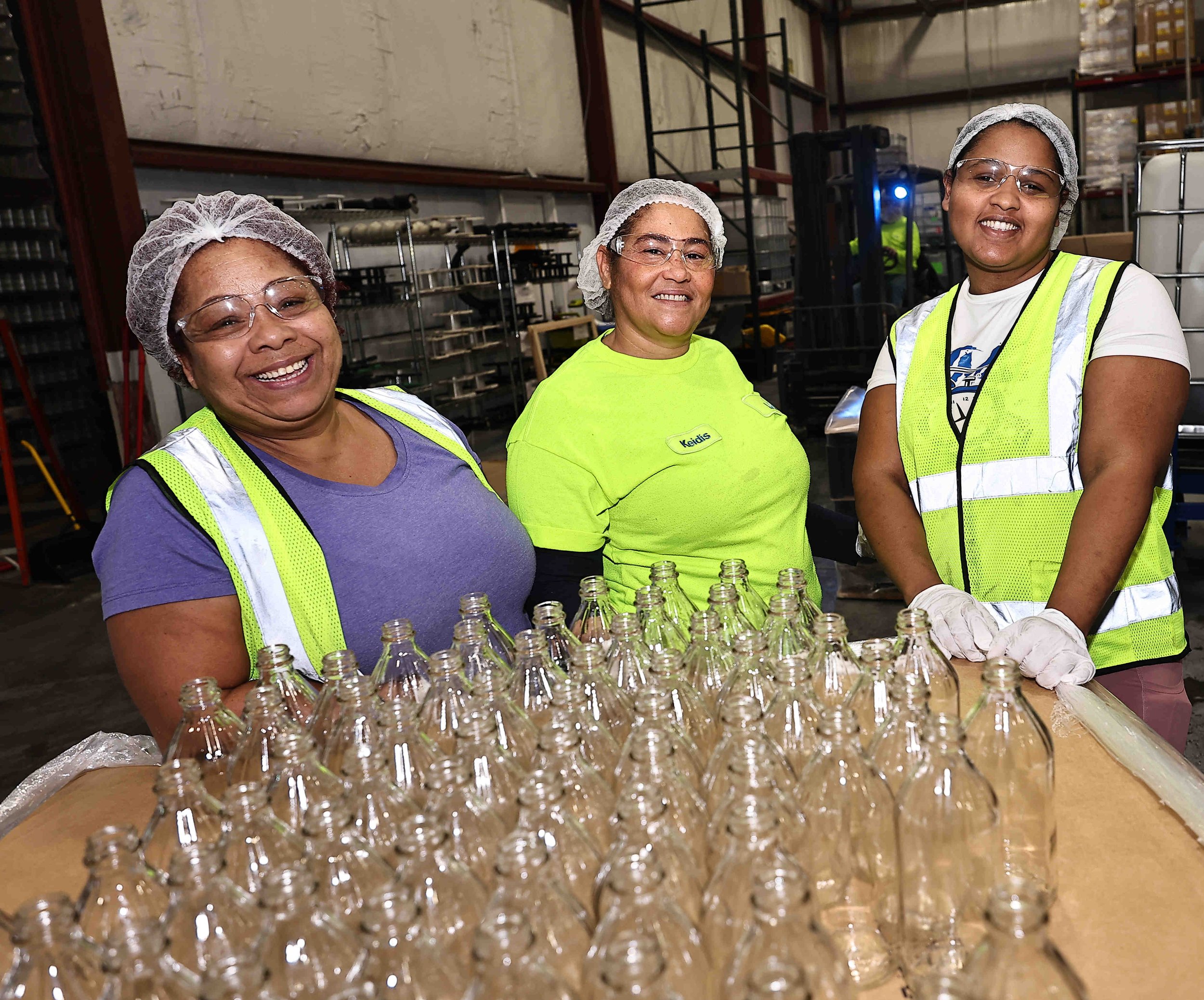 Three female employees packing bottles