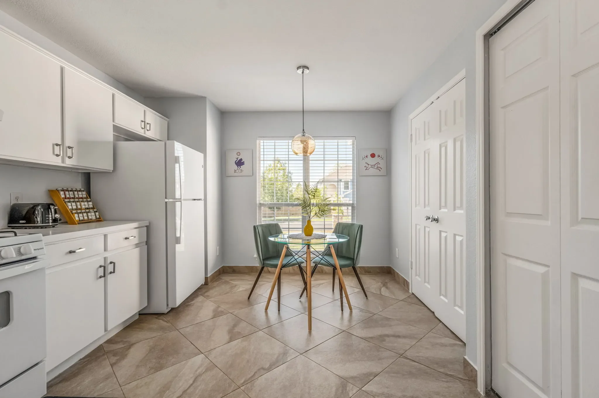 Vintage-style kitchen with a small glass bistro table and bright natural lighting.