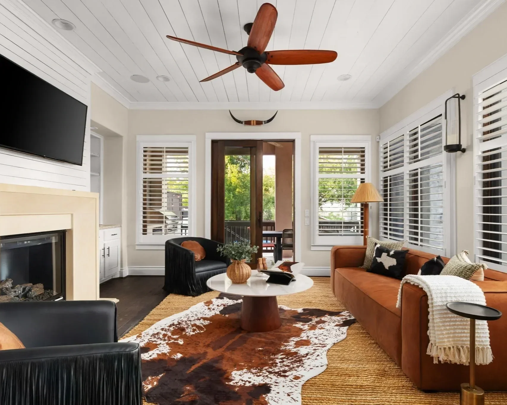 Sunset Saloon short-term rental design project — modern western living room with leather sofa and cowhide rug, Austin TX.