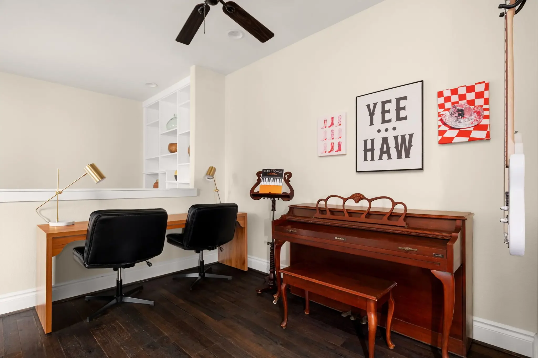 Short-term rental bonus room with upright piano, dual desks, and Yee Haw western wall art — Austin TX.