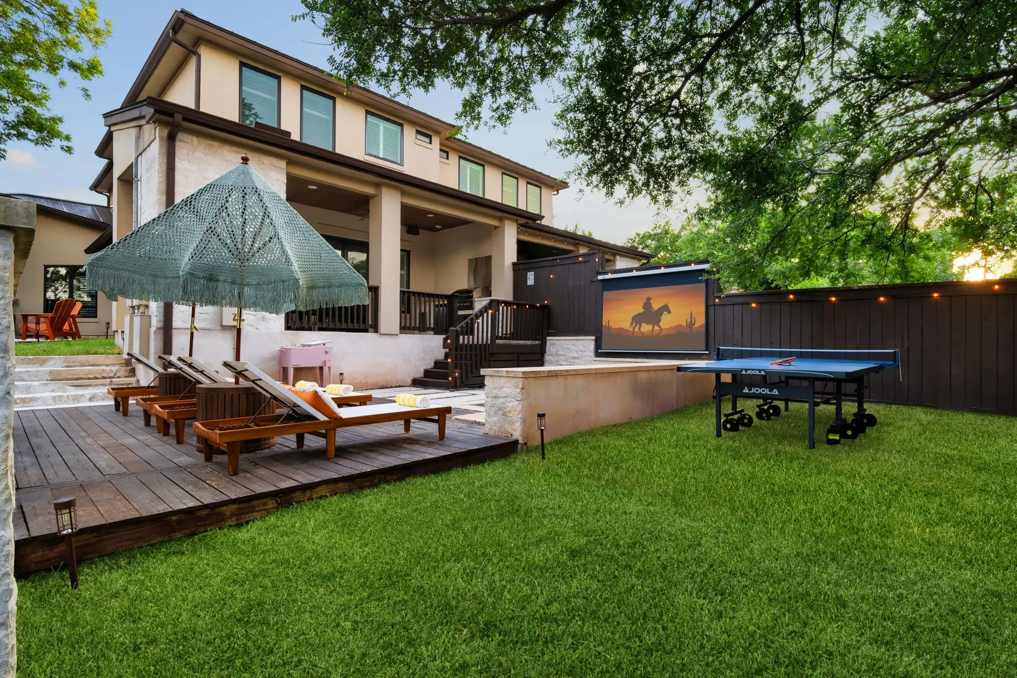 Airbnb outdoor design with lounge area, ping pong table, outdoor movie screen, and landscaped backyard — Austin TX.
