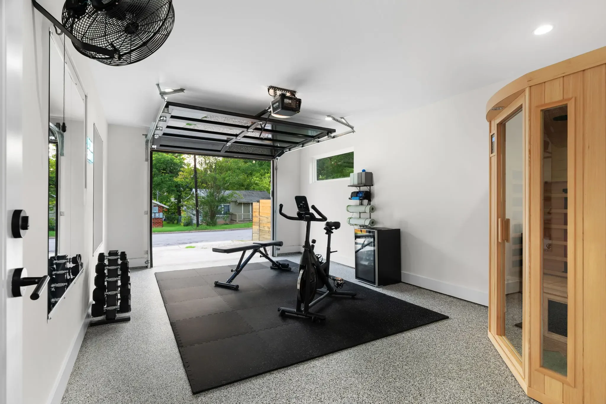Short-term rental home gym design with garage conversion, exercise bike, free weights, and cedar infrared sauna — Austin TX.