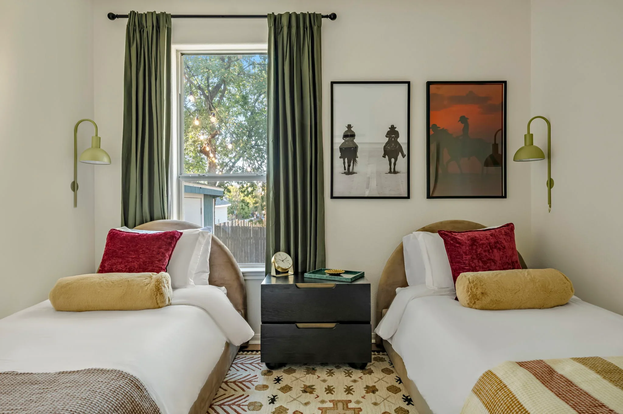 Short-term rental double bedroom design with curved velvet headboards, green curtains, black nightstand, and western cowboy wall art — Austin TX.
