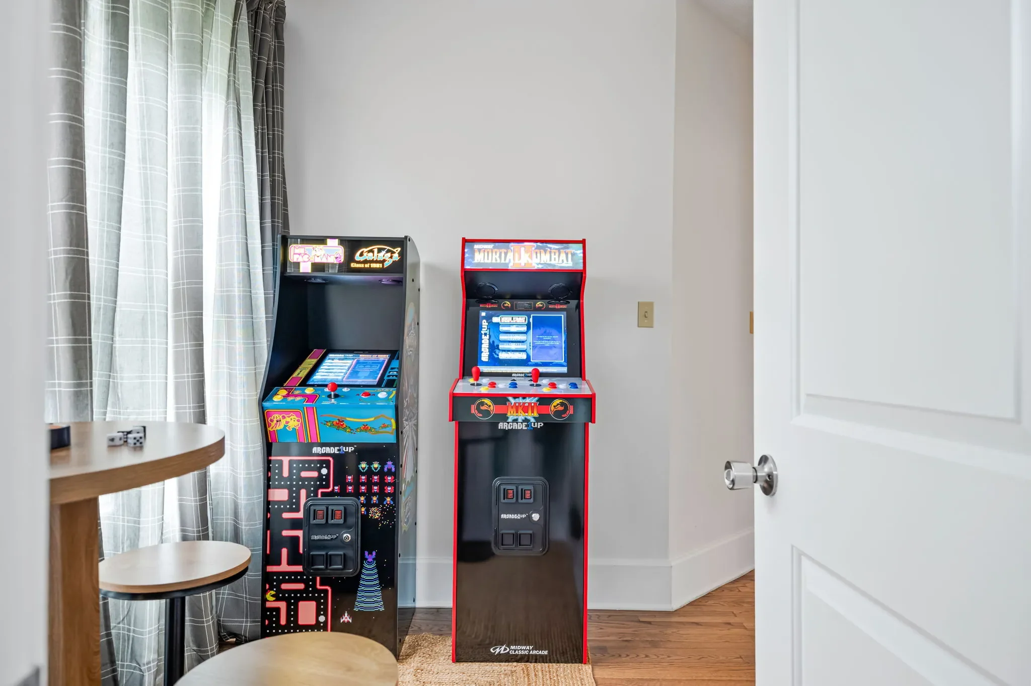 Airbnb game room design with two full-size arcade machines including Pac-Man and Mortal Kombat — Austin TX.