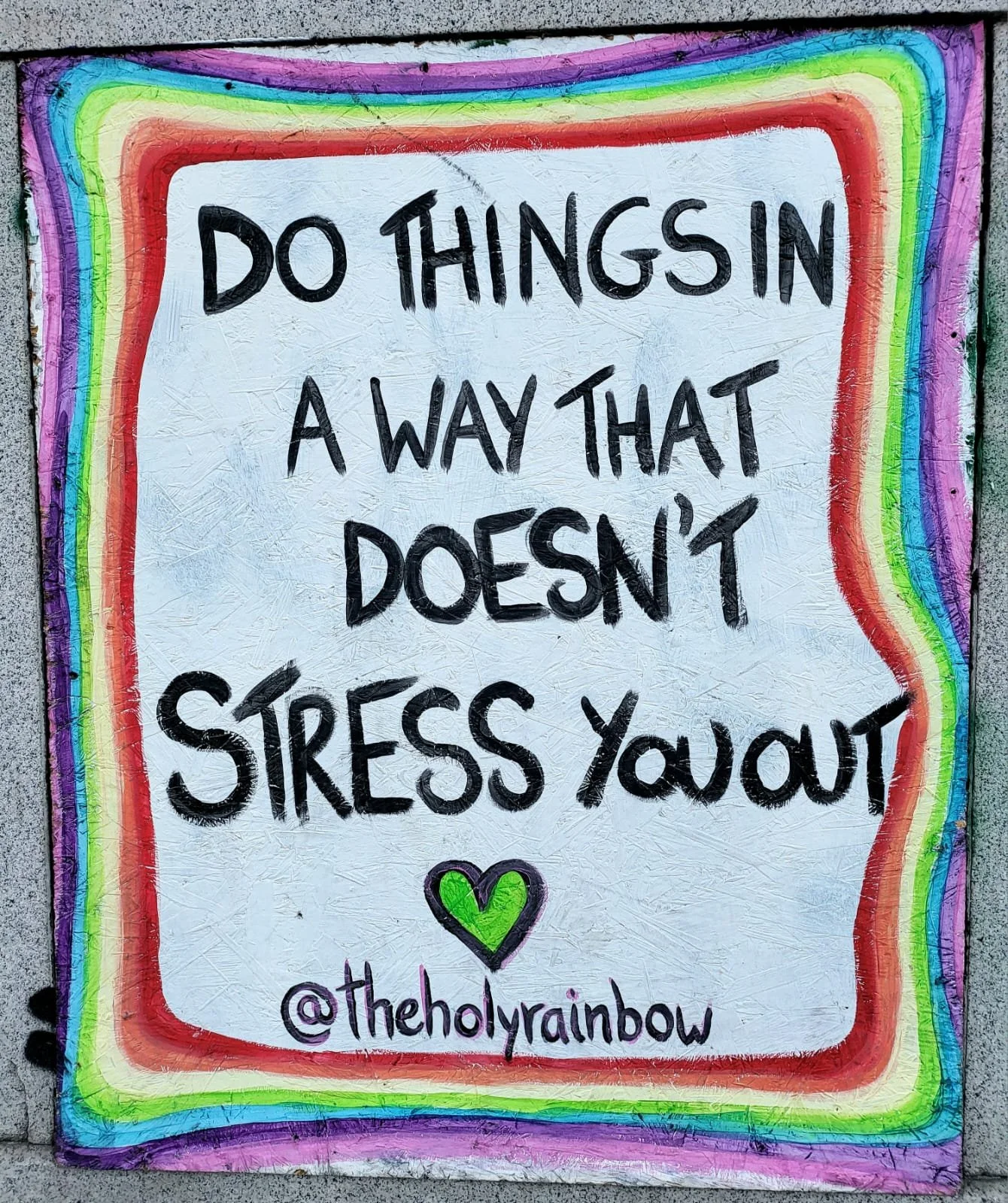 Colorful graffiti wall with a quote that says, 'Do things in a way that doesn't stress you out,' surrounded by a rainbow-colored border and a black-and-green heart at the bottom, with the Instagram handle '@theholyRainbow'.