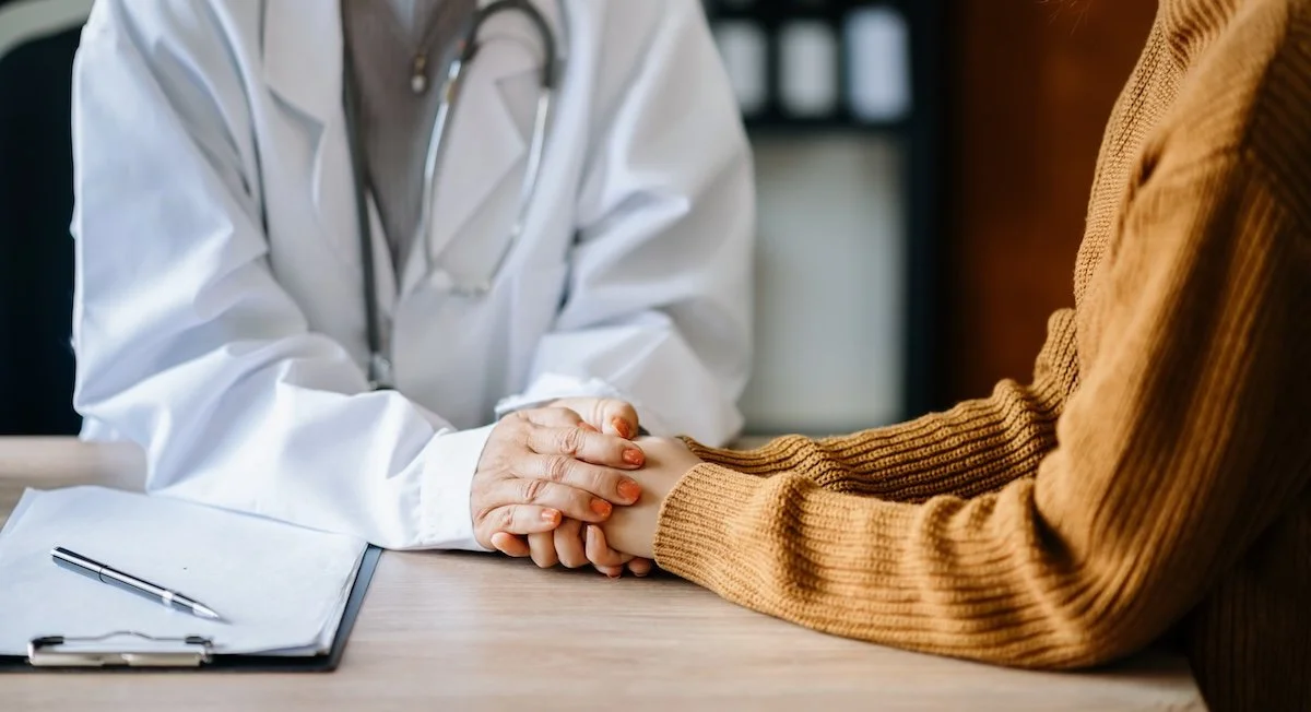 A concierge doctor in Philadelphia holding the hand of a patient.