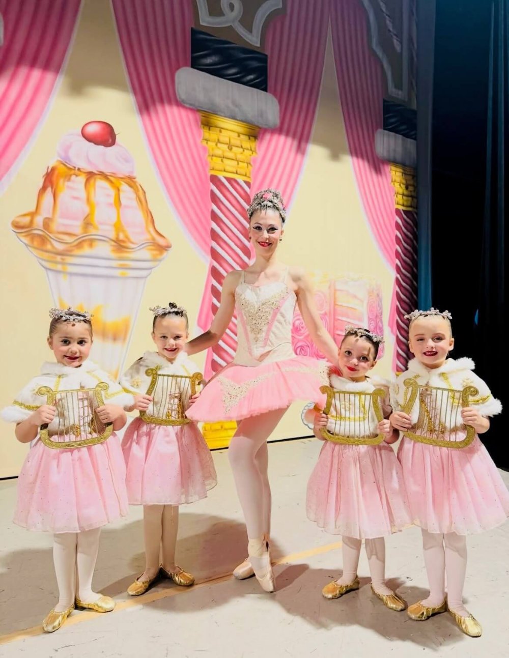 Emily Ricca professional ballet educator posing with young ballet students in pink tutus