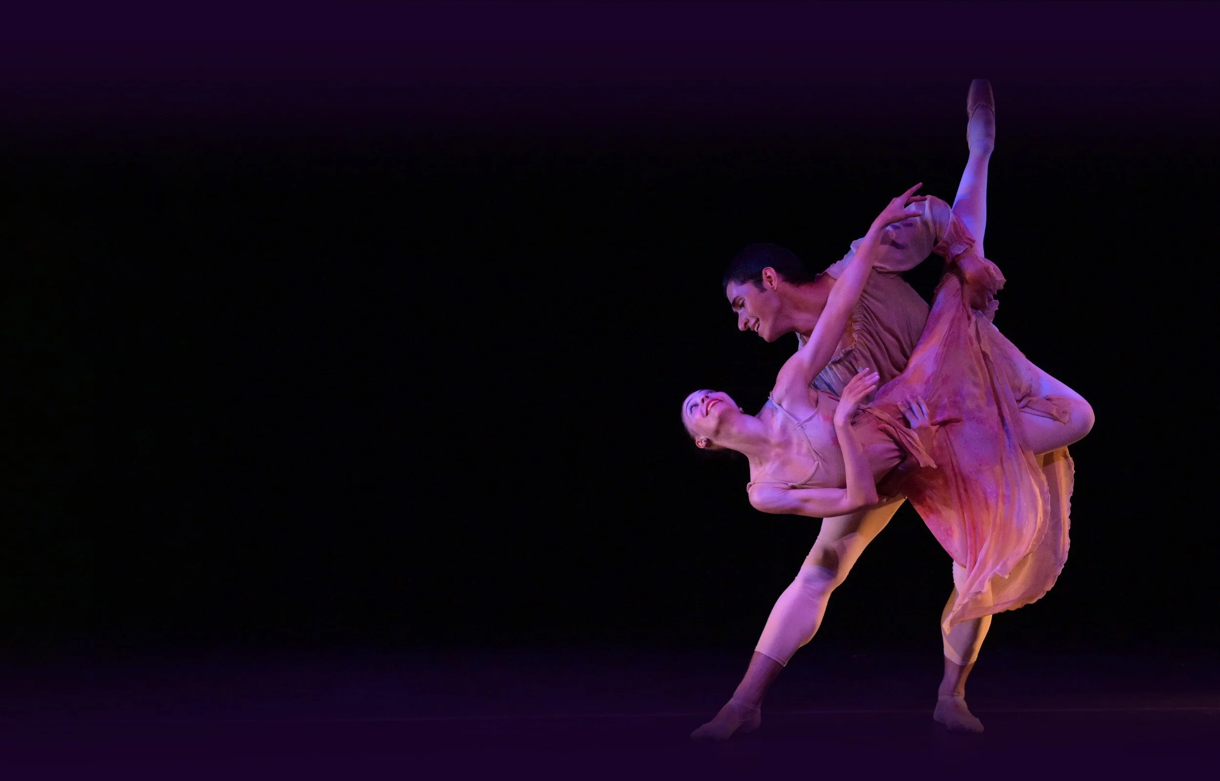 Emily Ricca professional ballet dancer performing contemporary pas de deux lift on stage with purple stage lighting