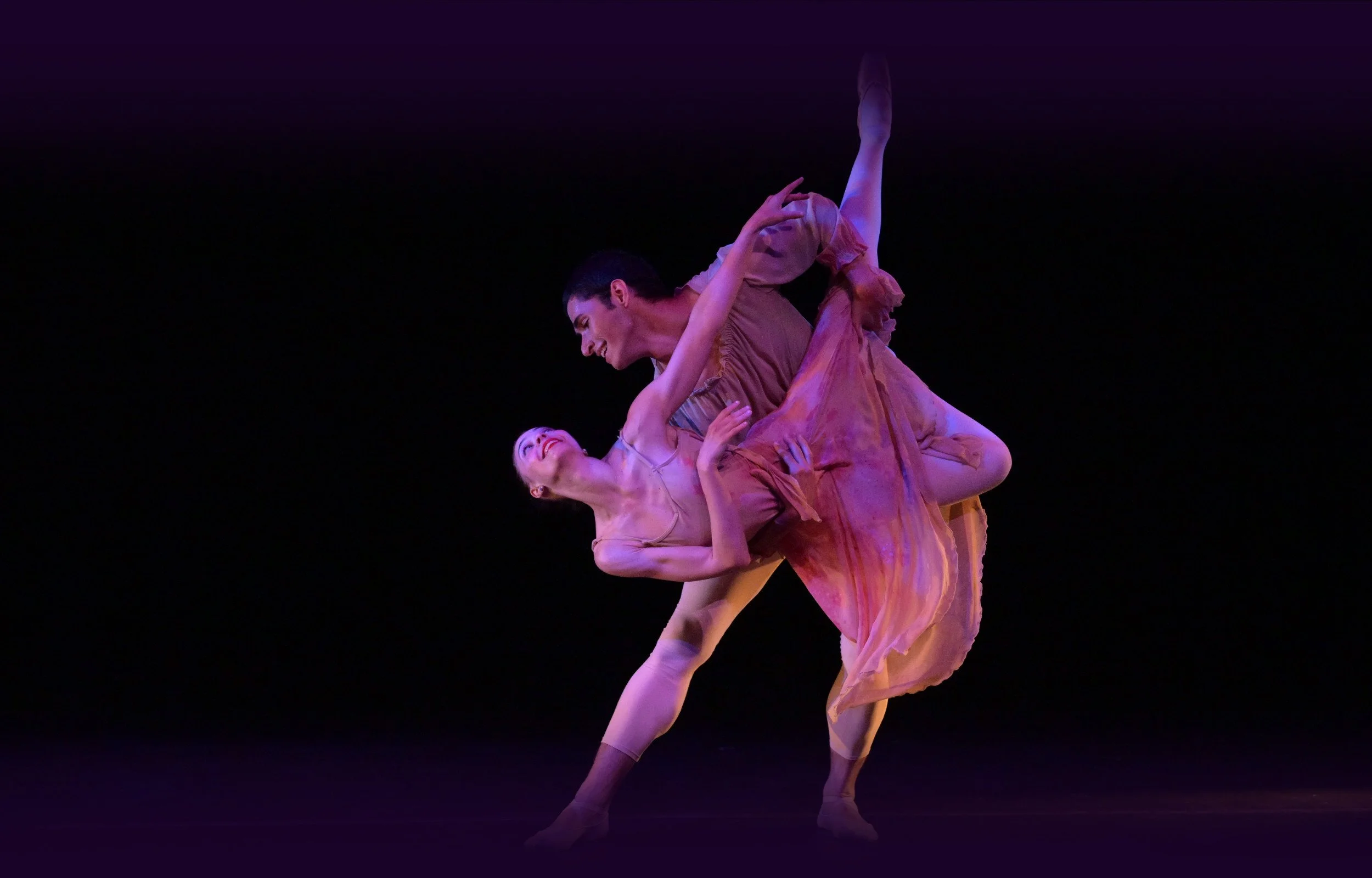 Emily Ricca professional ballet dancer performing contemporary pas de deux lift on stage with purple stage lighting
