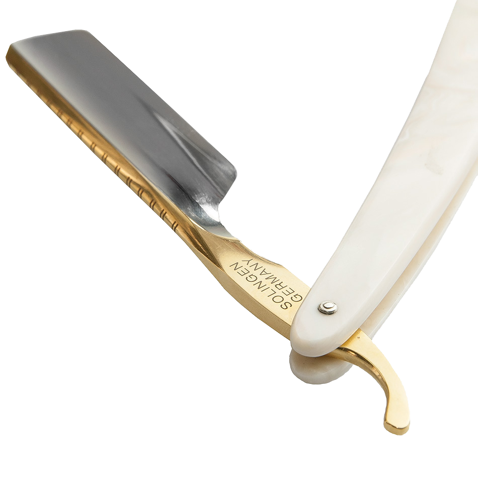 Een scheermes met een witte handvat en een gouden metalen deel, gelegen op een wit oppervlak.