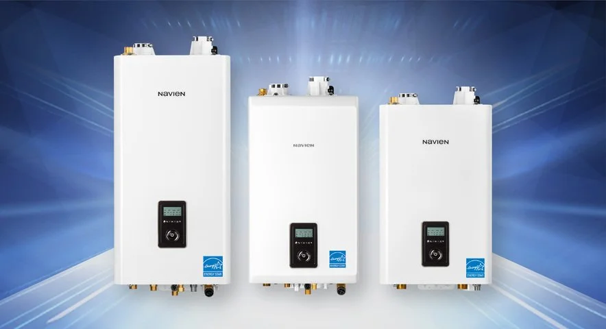 Three white Navien tankless water heaters with digital displays, positioned against a blue background with light streaks.