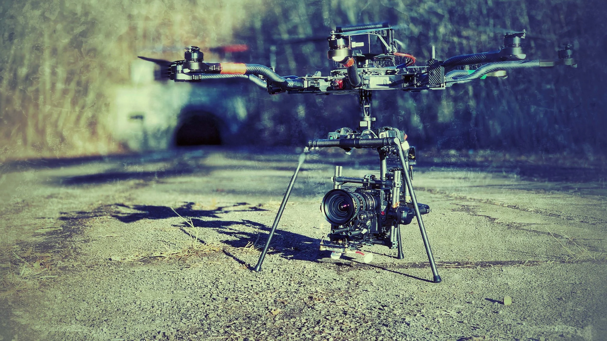 A drone with a mounted camera on the ground near a tunnel entrance.