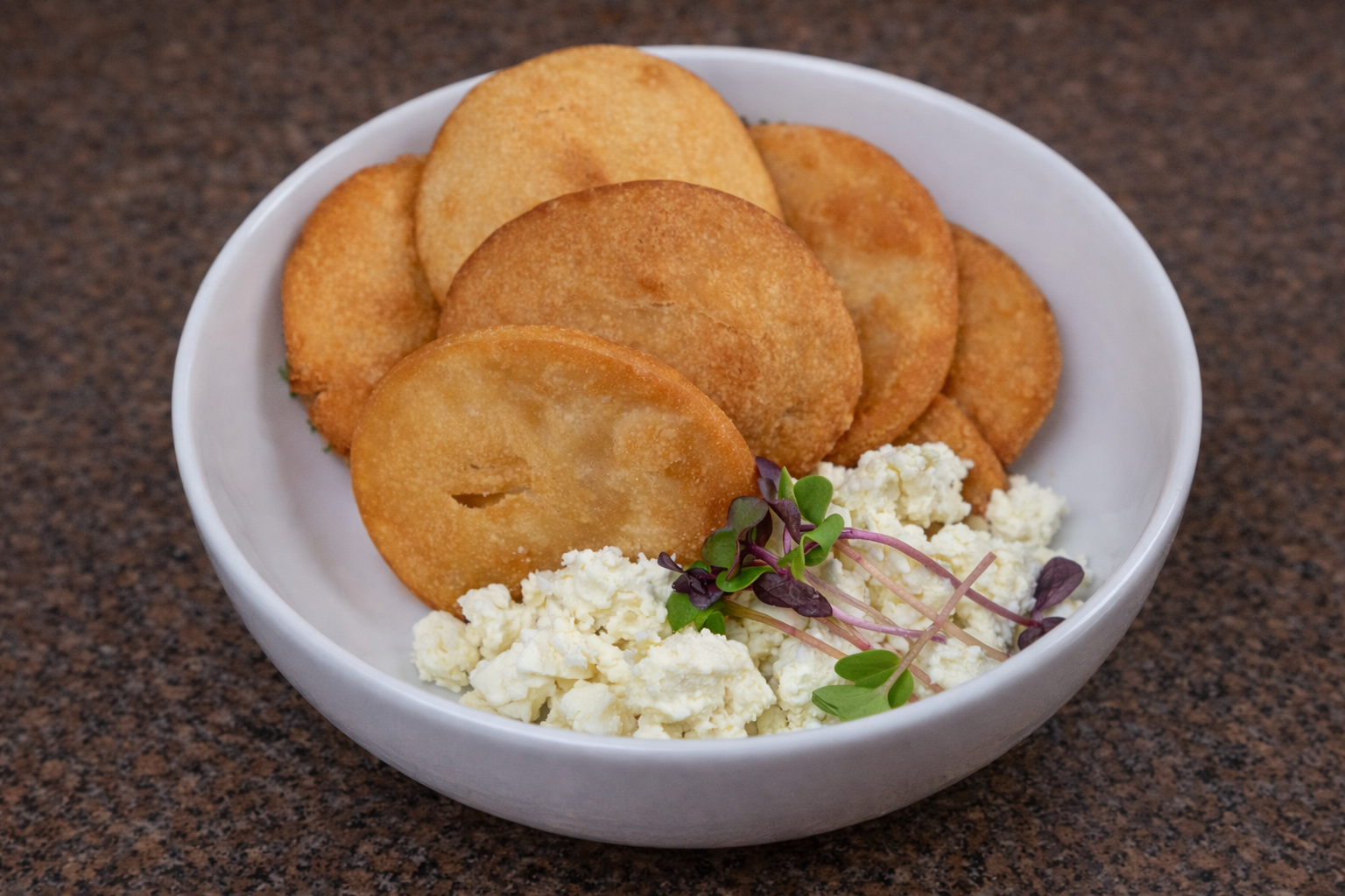 Golden arepas with cheese and microgreens.png