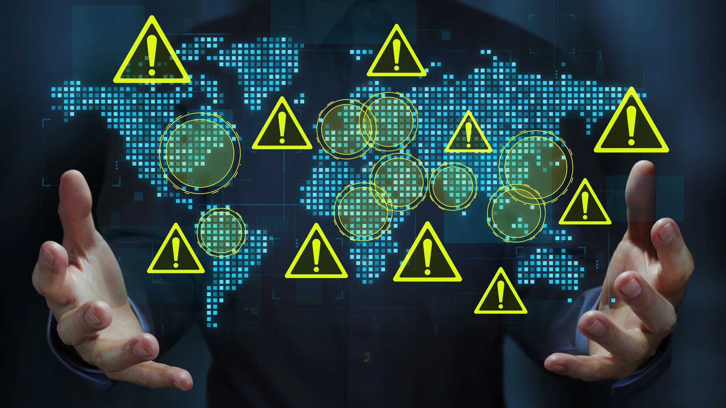 A person in a suit points at a digital world map with blue squares, yellow warning triangles with exclamation marks, and circular warning symbols, indicating global alerts or cybersecurity issues.