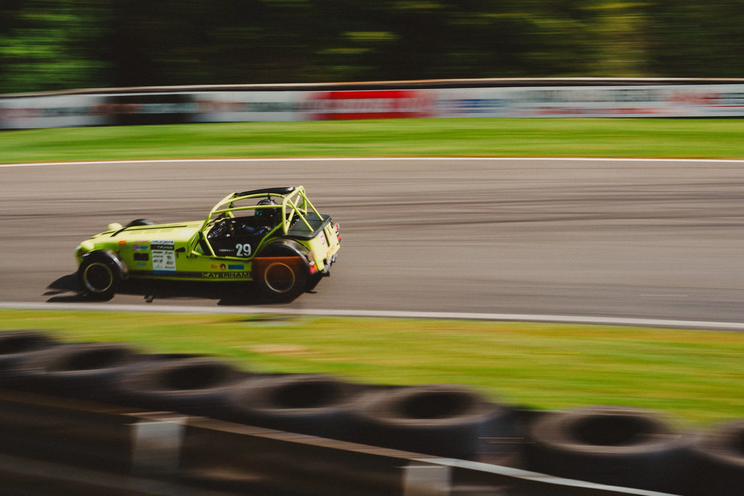 A bright yellow race car speeding on a race track, captured with motion blur.