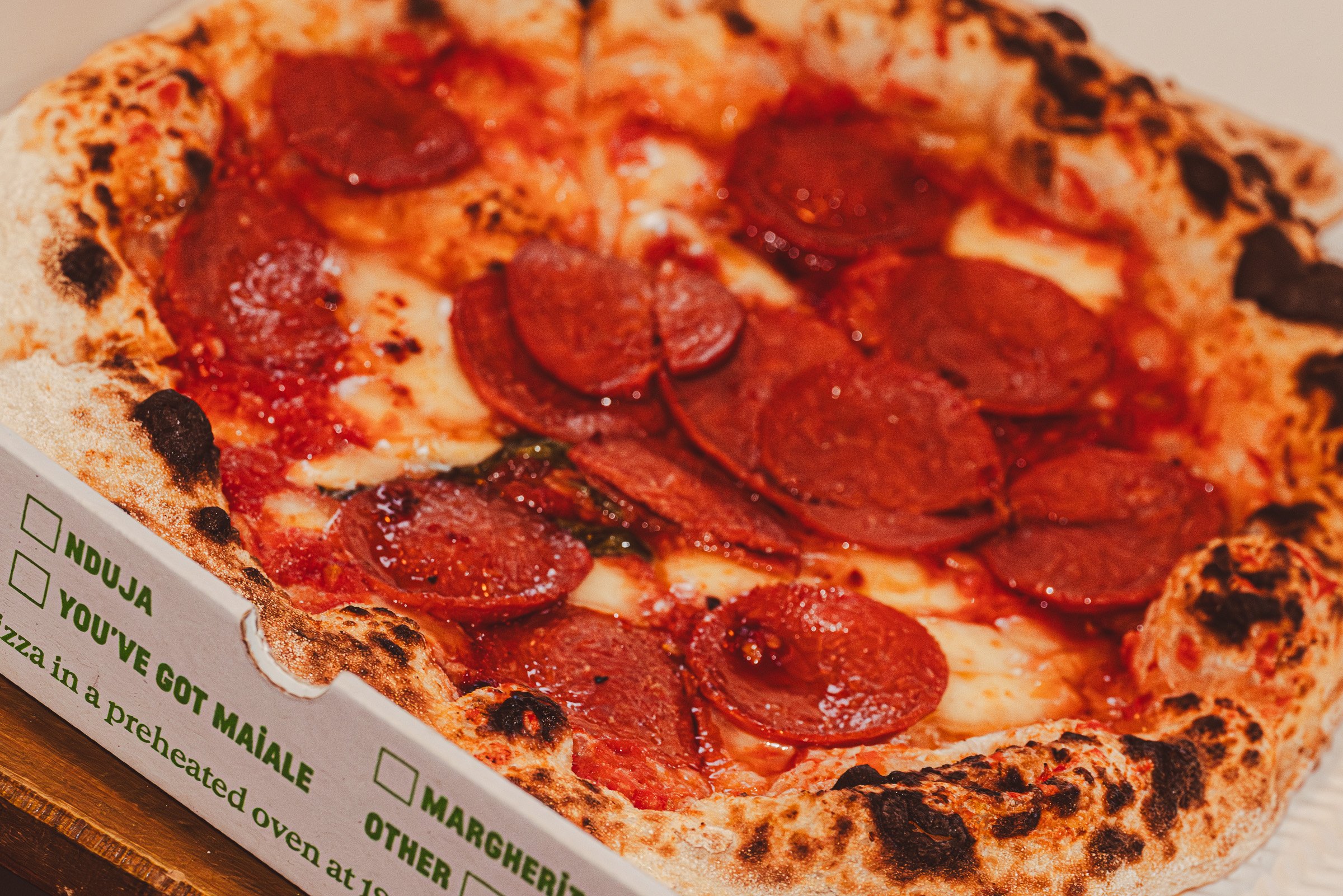 Close-up of a pepperoni pizza with cheese on a box