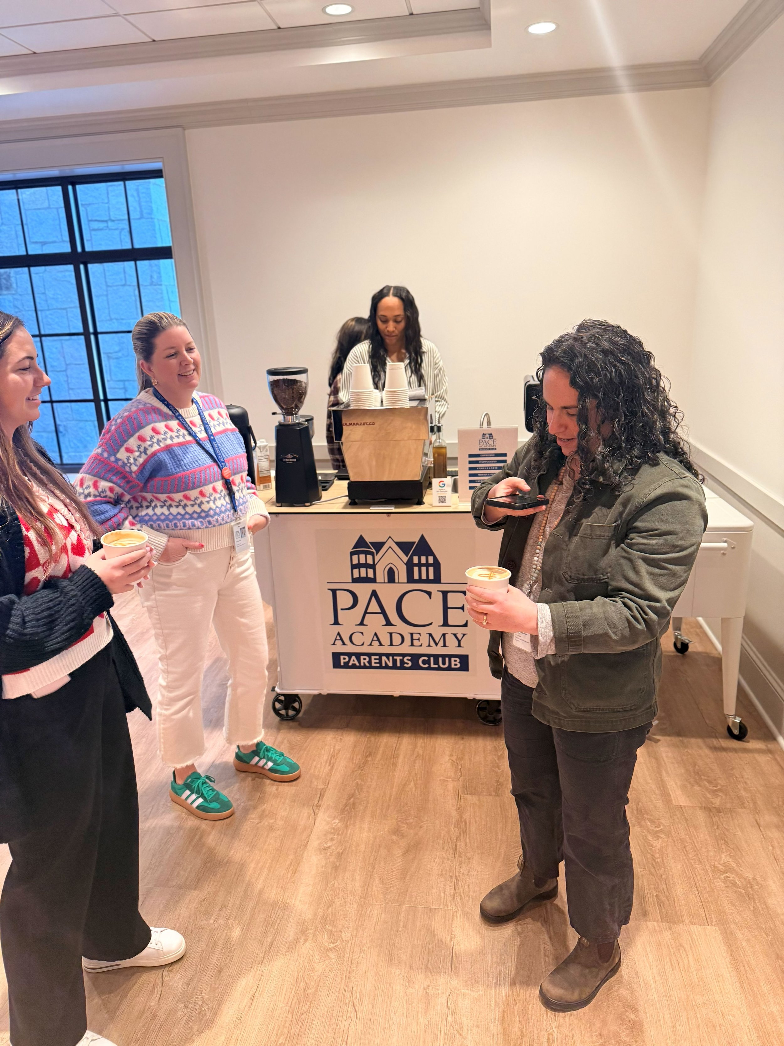 Two teachers posing with drinks at Atlanta coffee catering event