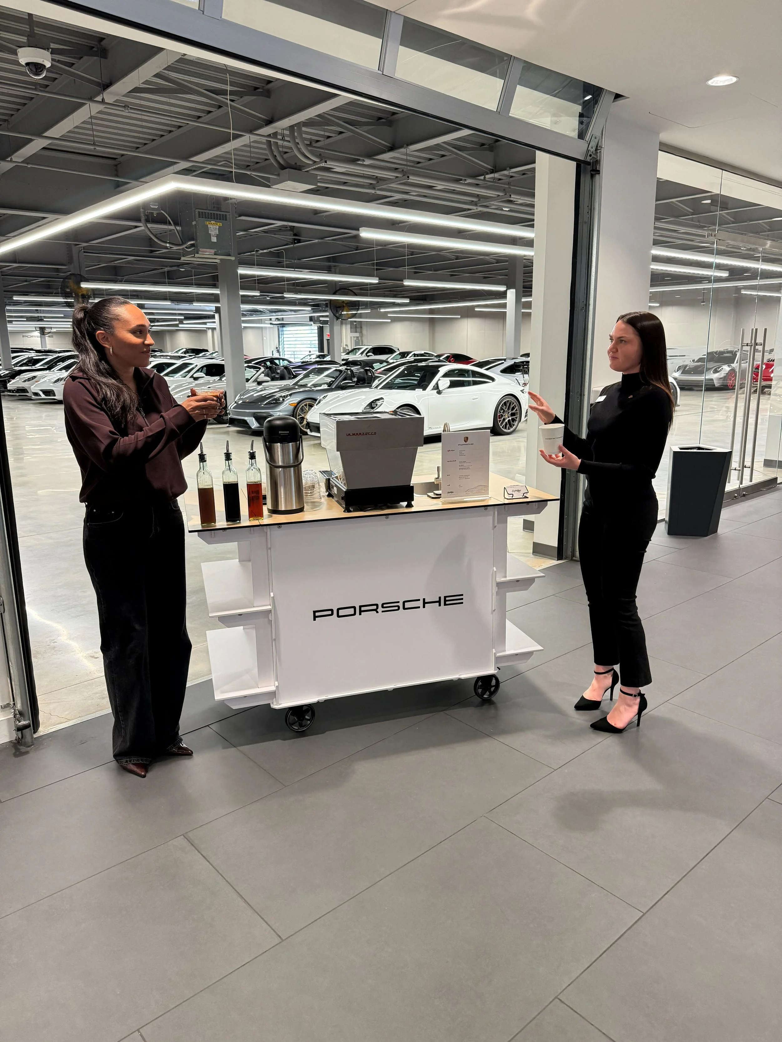 Barista preparing handcrafted espresso drinks for guests at a Porsche Atlanta event