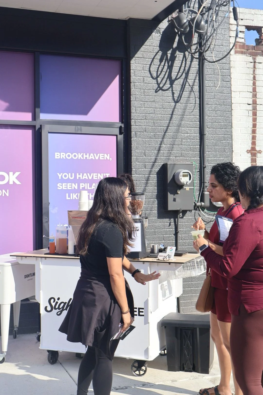 Founding member holding coconut cream iced coffee at Brookhaven studio opening
