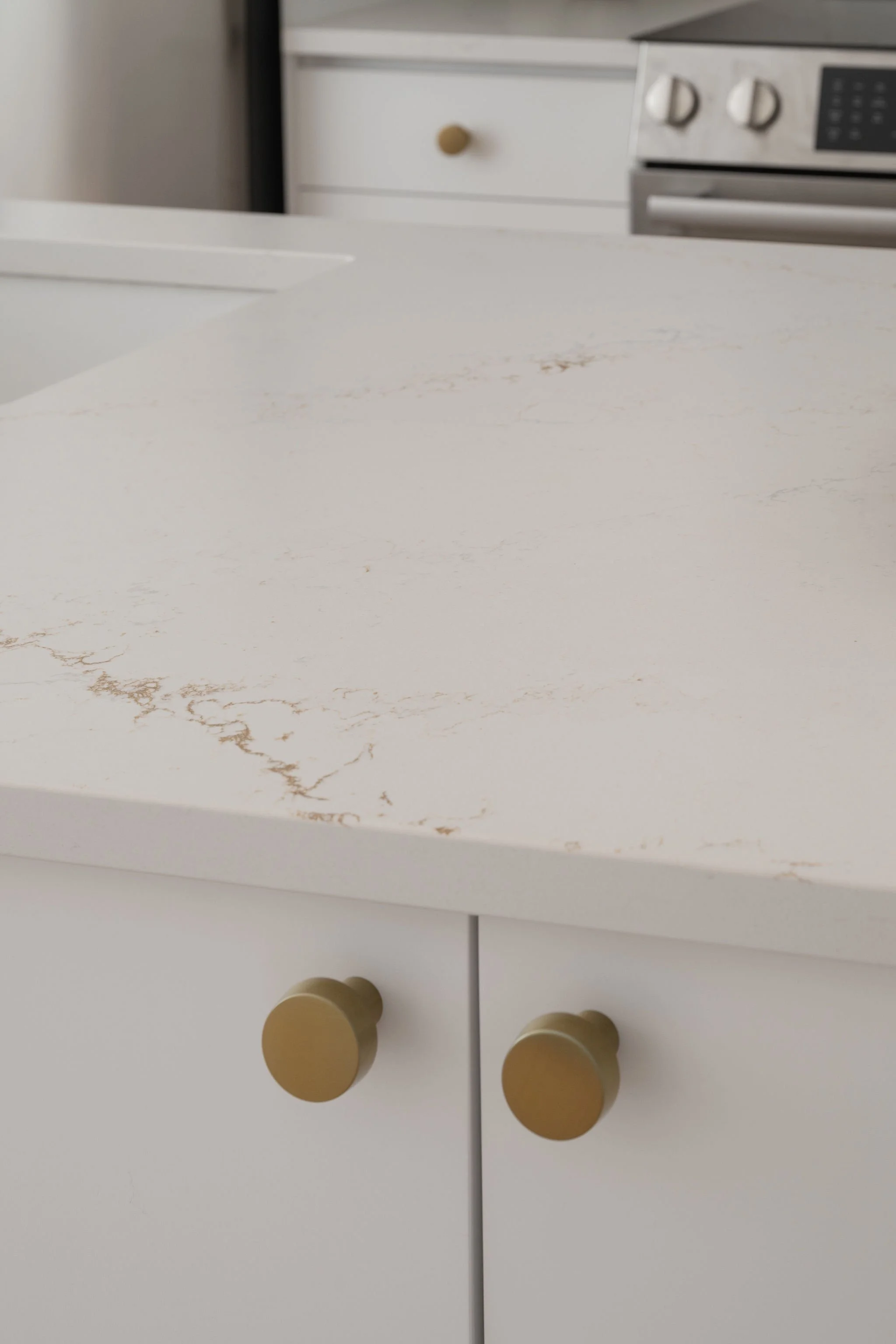 Gold knobs on white kitchen cabinet