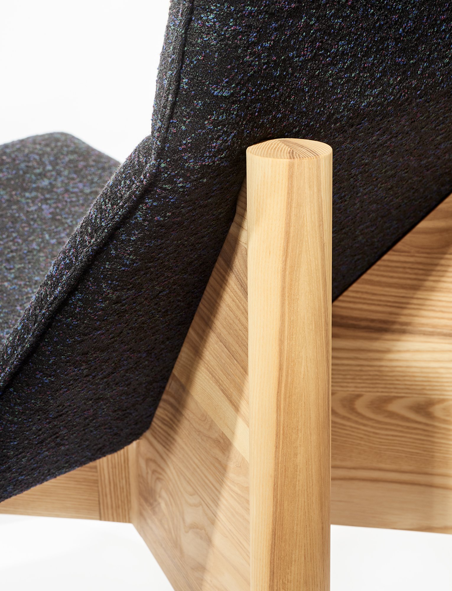 Detail of the alder lounge chair’s ash joinery and the transition to the upholstered seat.