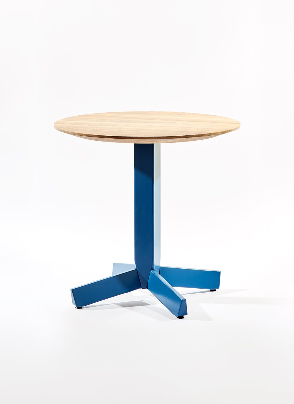 Peggy Table featuring a rounded tabletop set on a faceted central base, highlighting its balanced proportions, customizable materials, and quiet sculptural presence in the Ourse lineup.