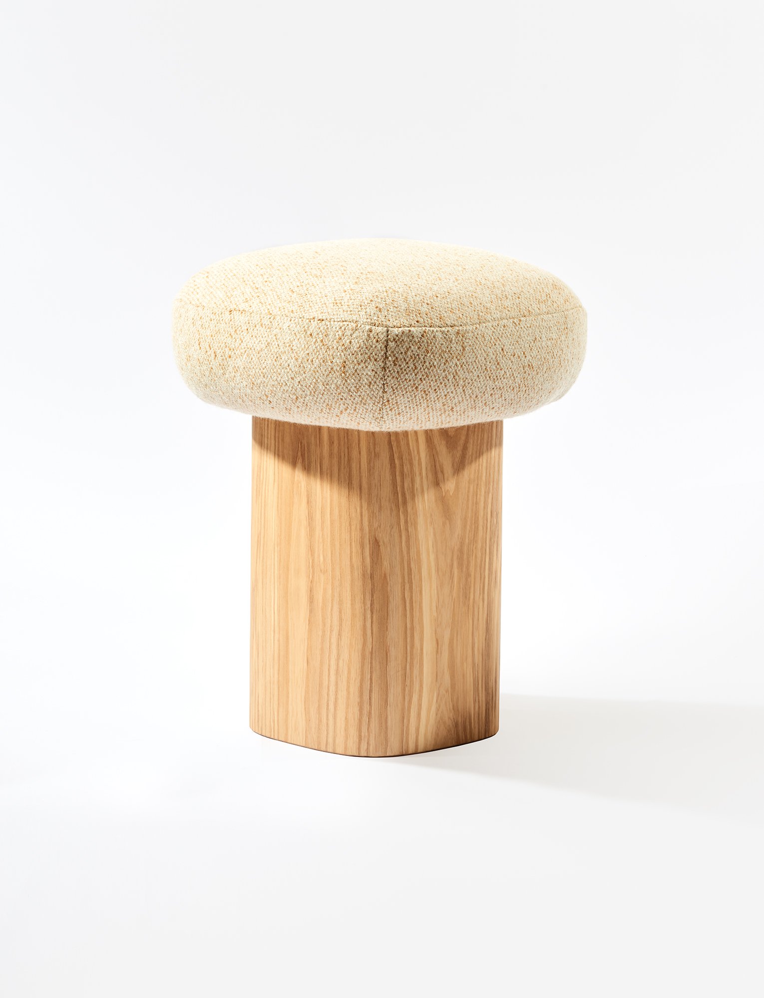 Soufflé Stool in its carved wood version, showcasing a smooth monolithic form and subtle sculpted shaping within the Ourse lineup.