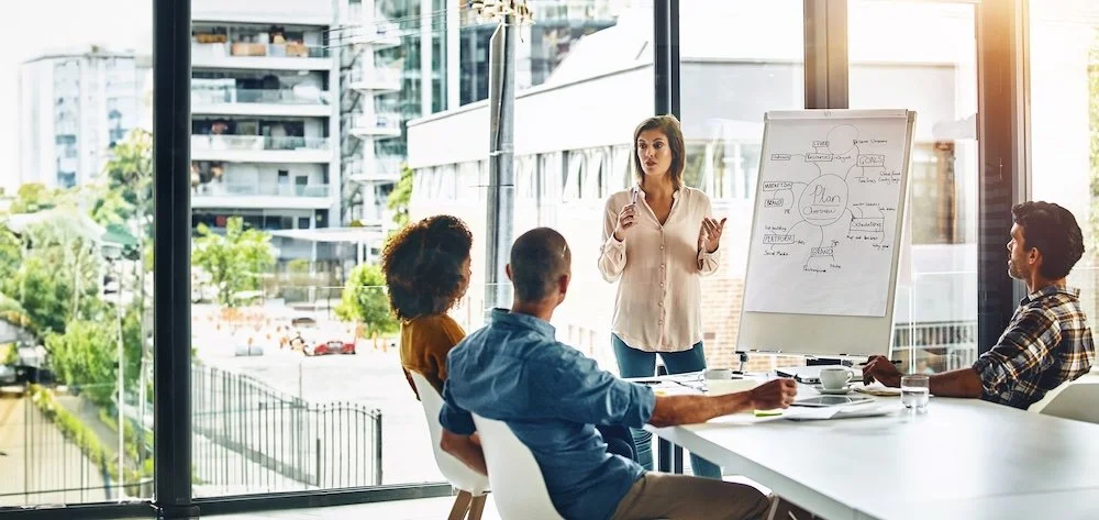 woman presenting to two people in a meeting room