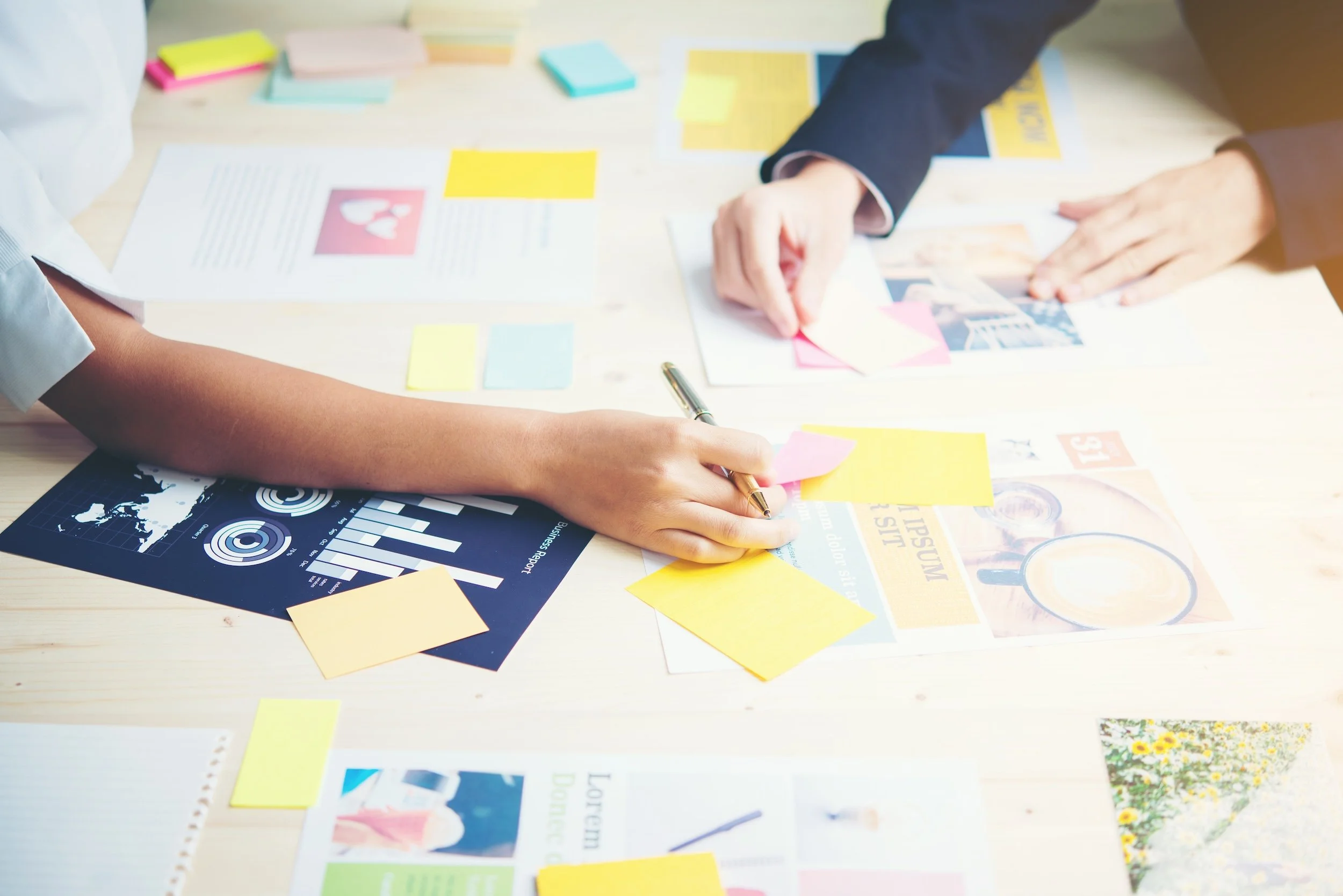 2 people writing on post-it notes