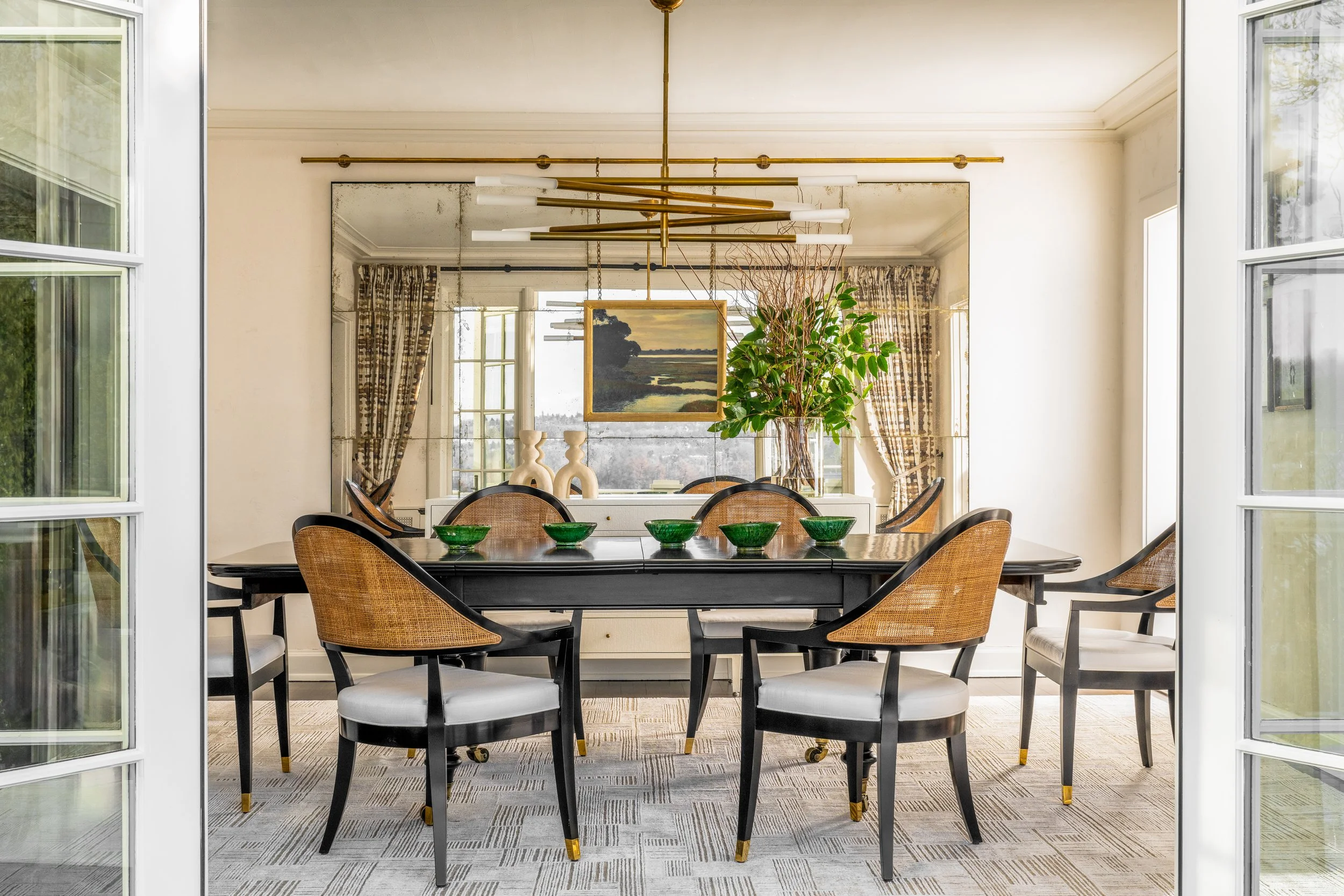 Elegant dining room with brass chandelier and cane back chairs in Seattle remodel