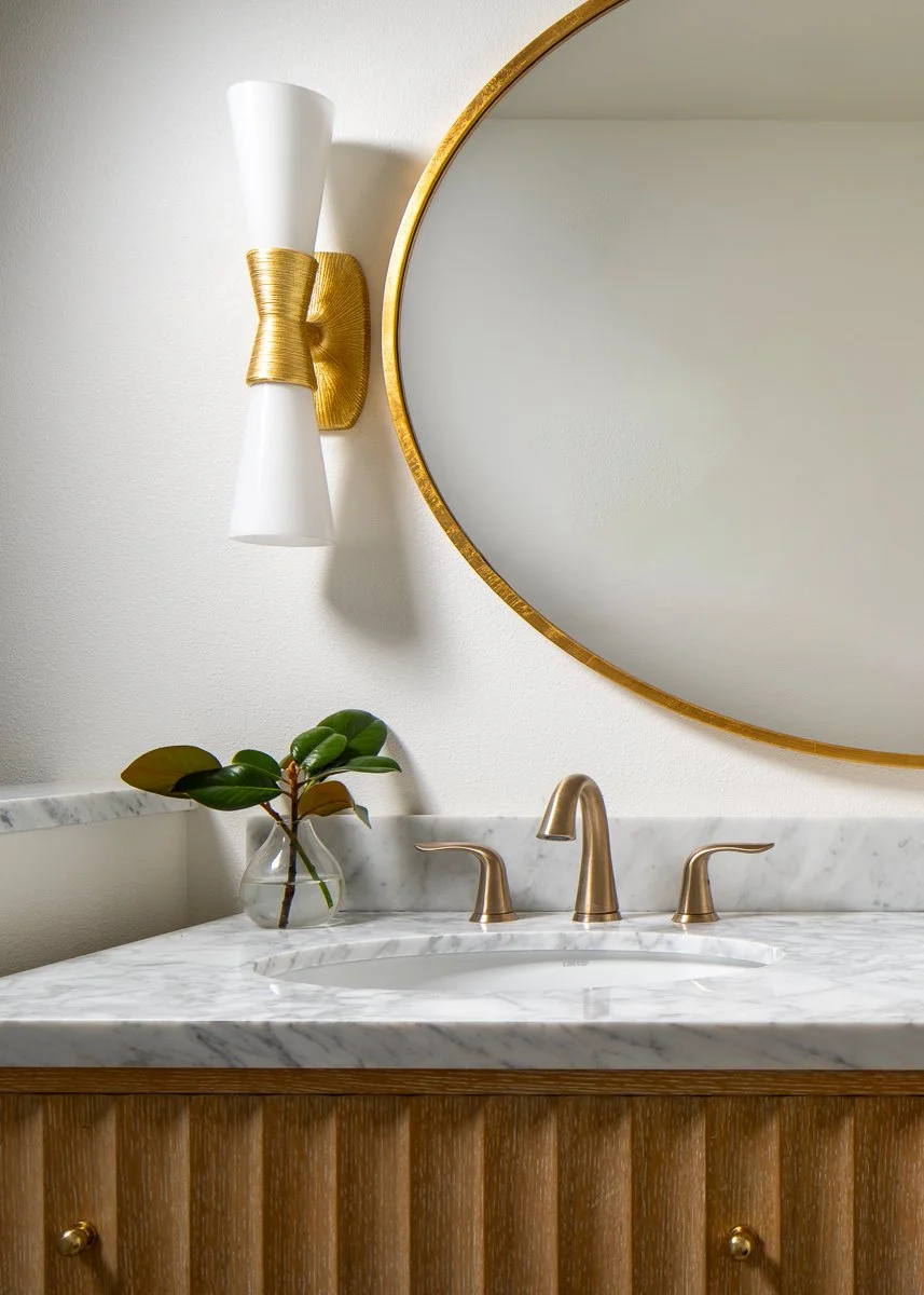 Professional interior photography of a Bainbridge Island luxury condo bathroom featuring fluted wood vanities, marble tops, and brushed gold accents.