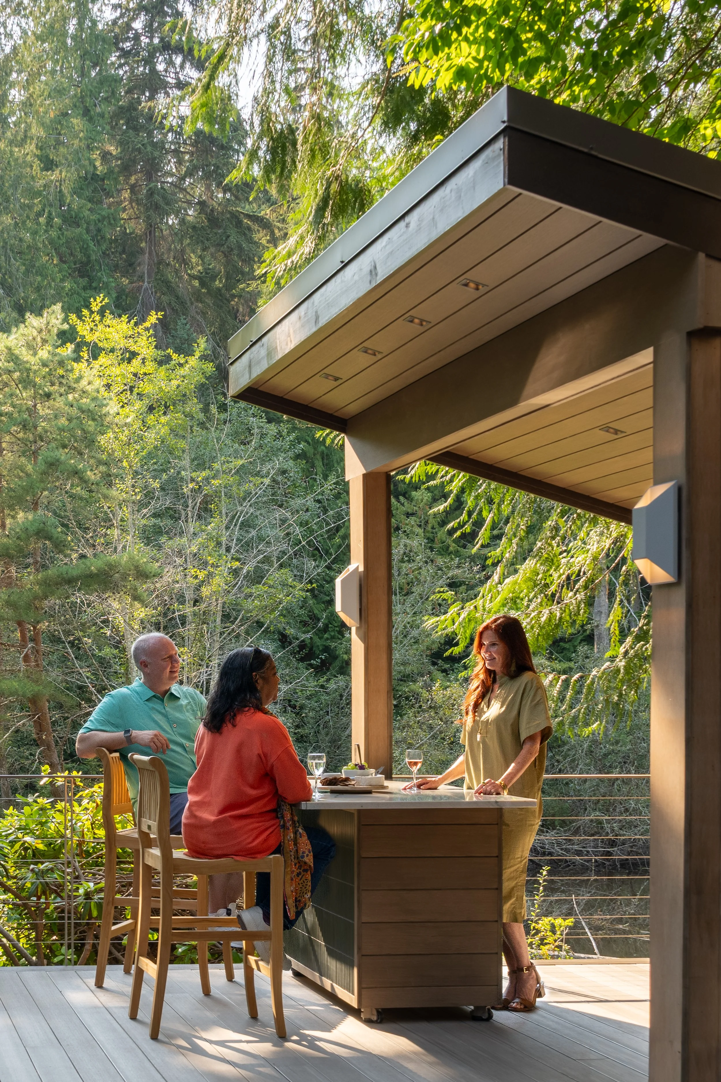 Bainbridge Island, WA | New Construction | People talking at outdoor kitchen island on a deck.