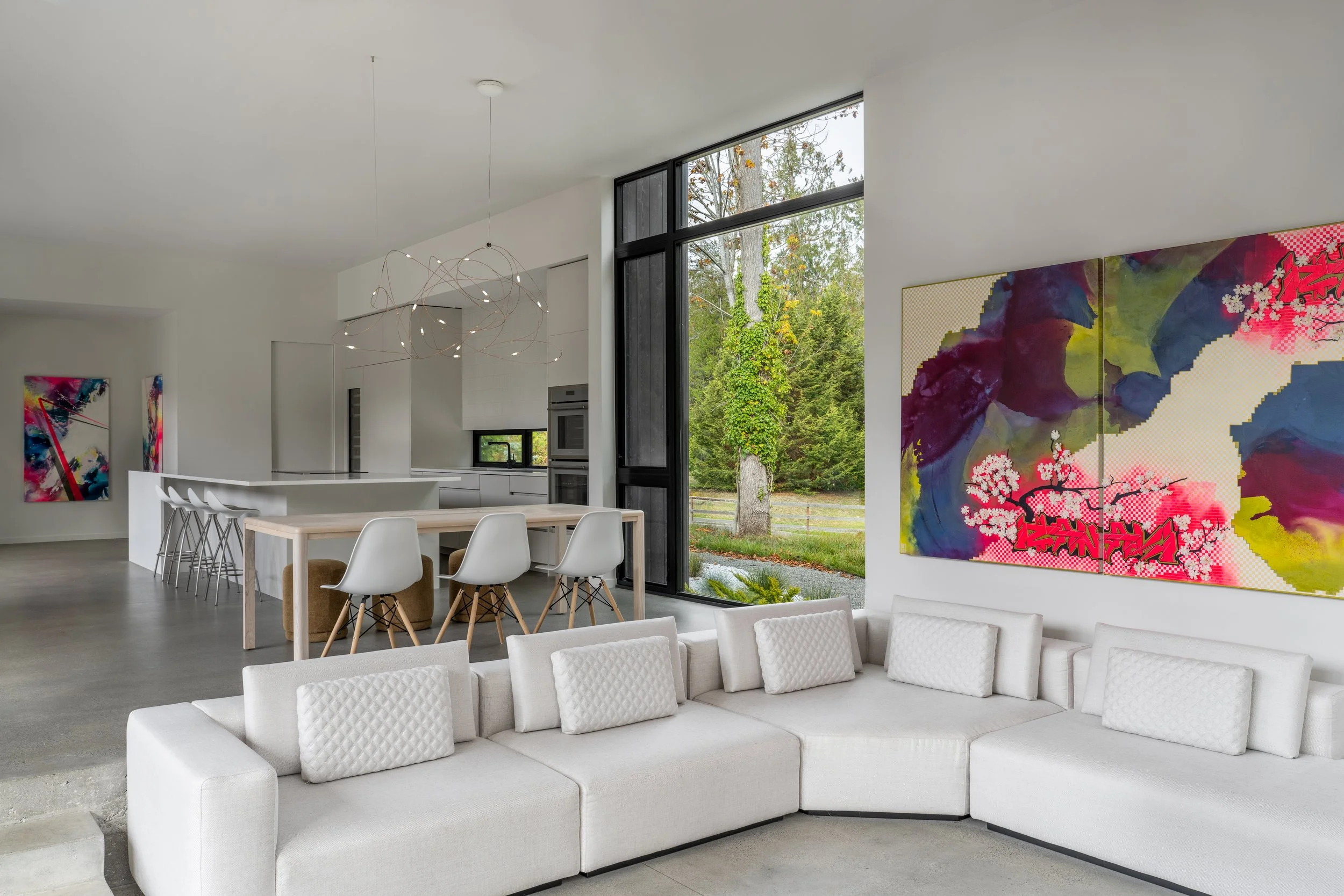 Bainbridge Island, WA | New Construction | Modern sunken Living Room with white sofa in front of dining room and kitchen