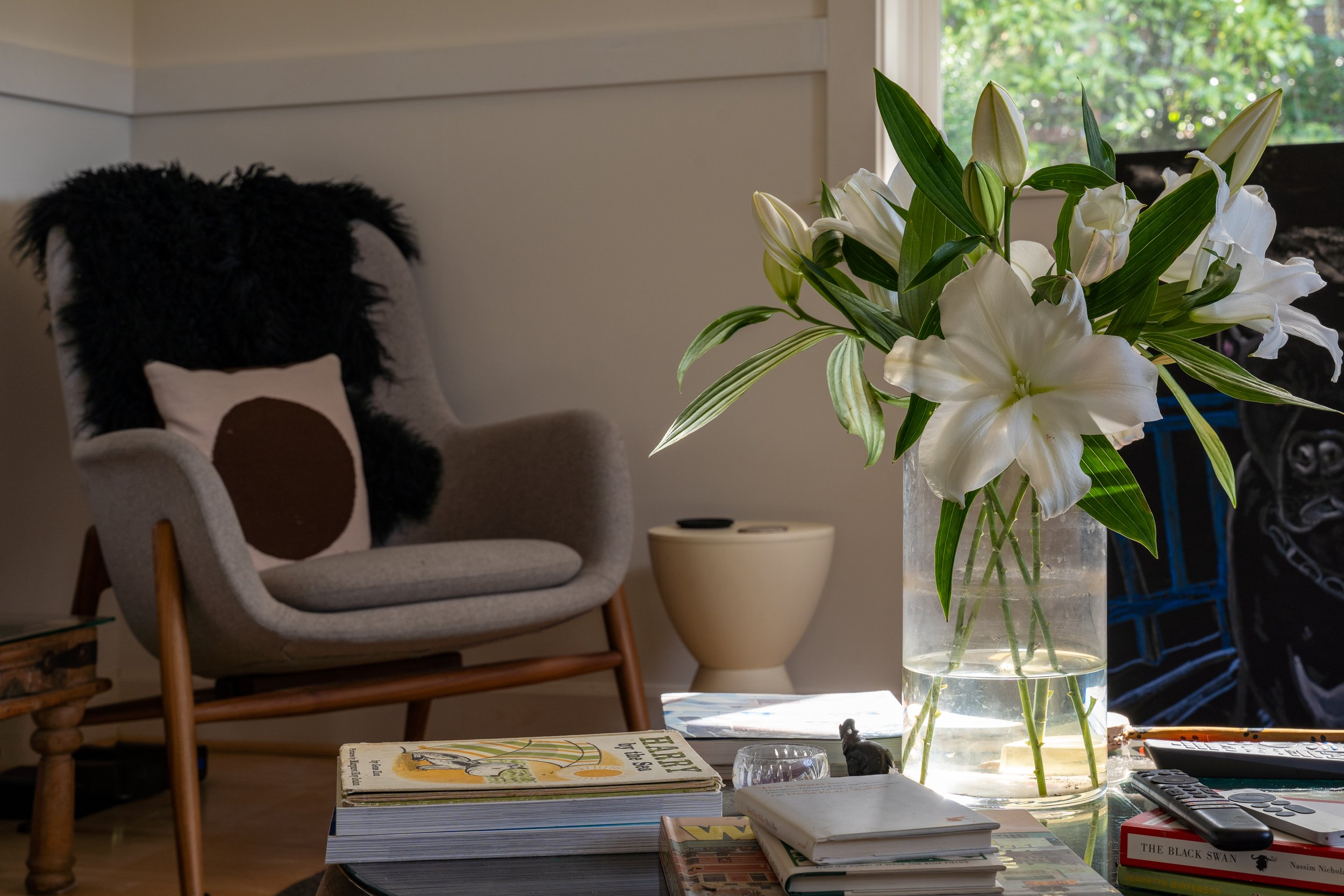 Bainbridge Island | Cozy Living Room Design | Coffee Table with Lilies and a Modern Chair with sheepskin