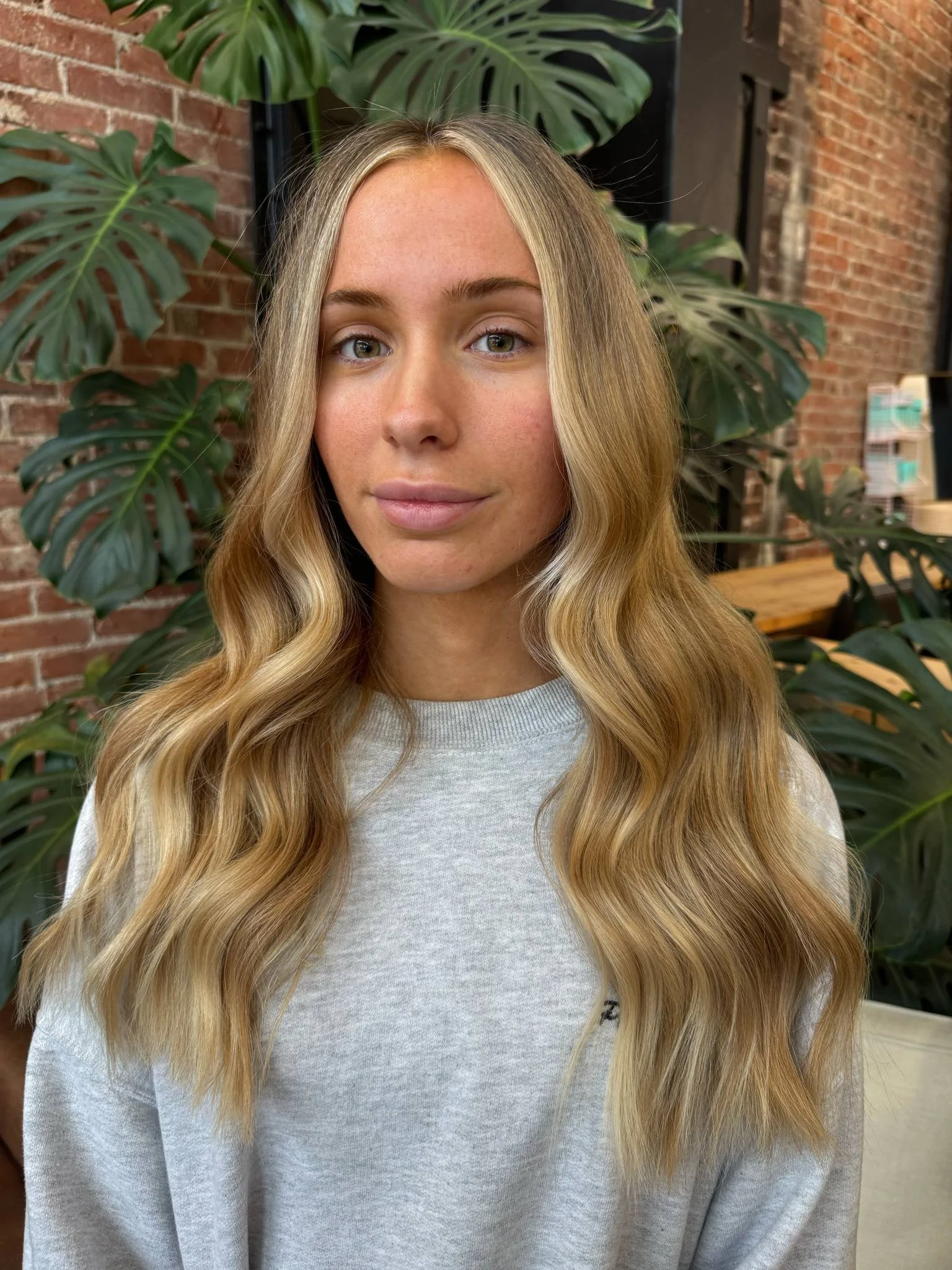 Golden blonde hair with soft face-framing layers by Kaitlyn Coston