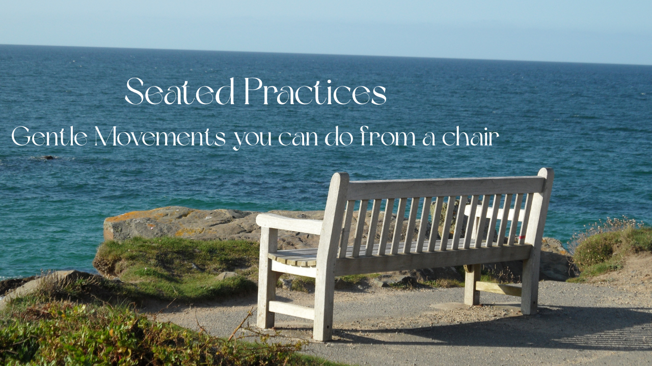 A wooden bench on a rocky coastline overlooking the ocean with a clear sky.