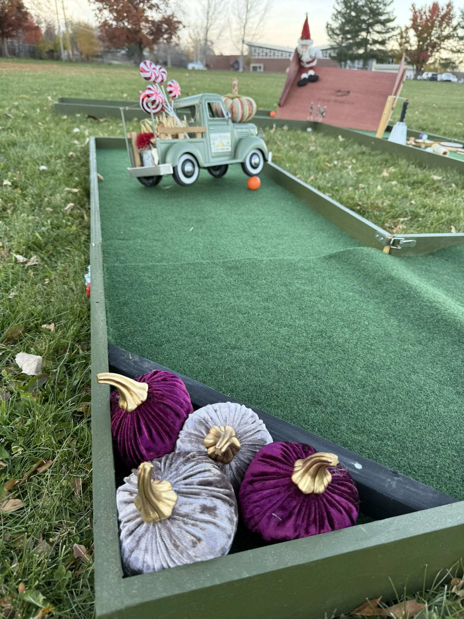 Mobile mini golf course with miniature vintage farm truck filled with red and white peppermint swirl candies.