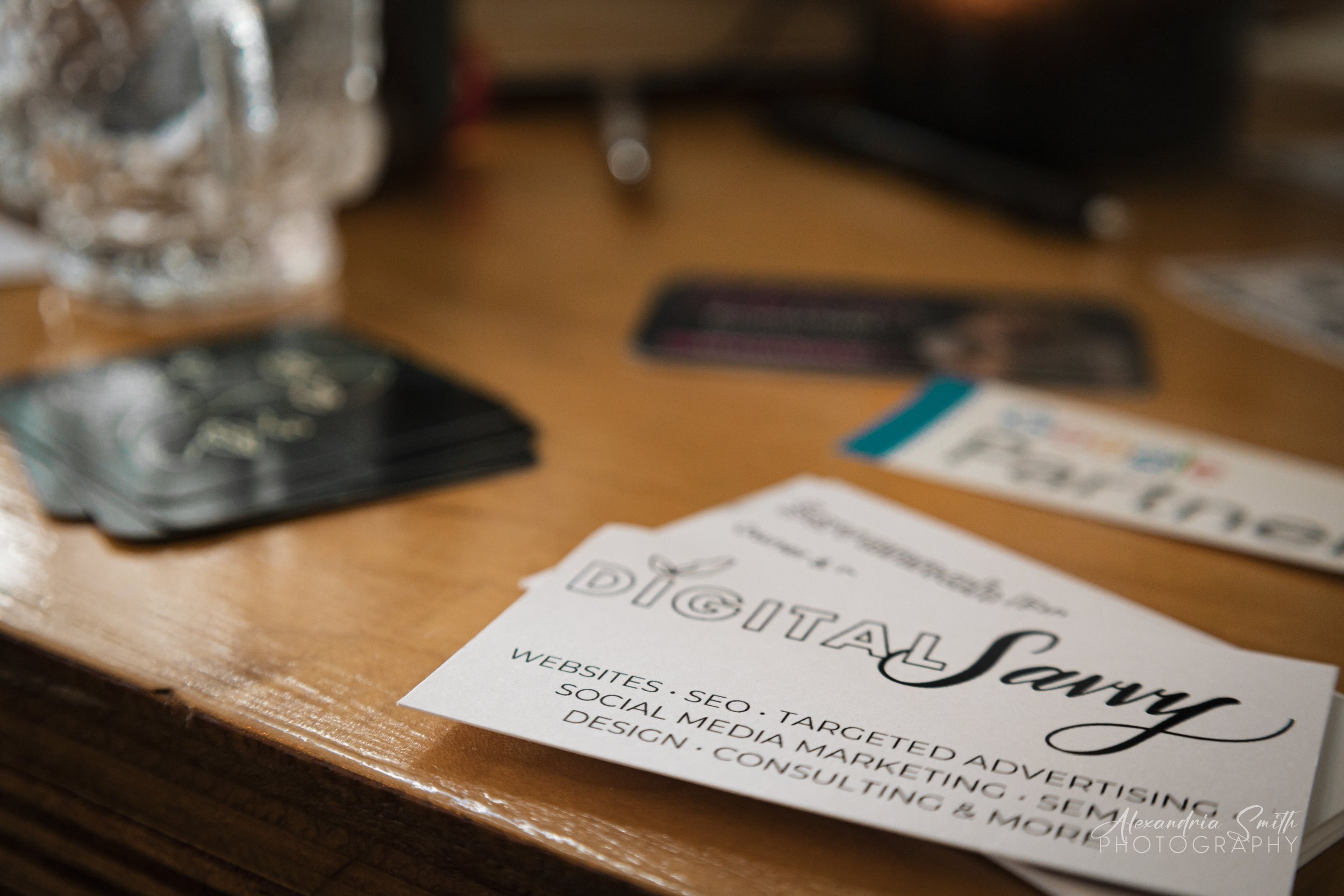 Business cards and flyer on a wooden table, promoting digital marketing and SEO services.