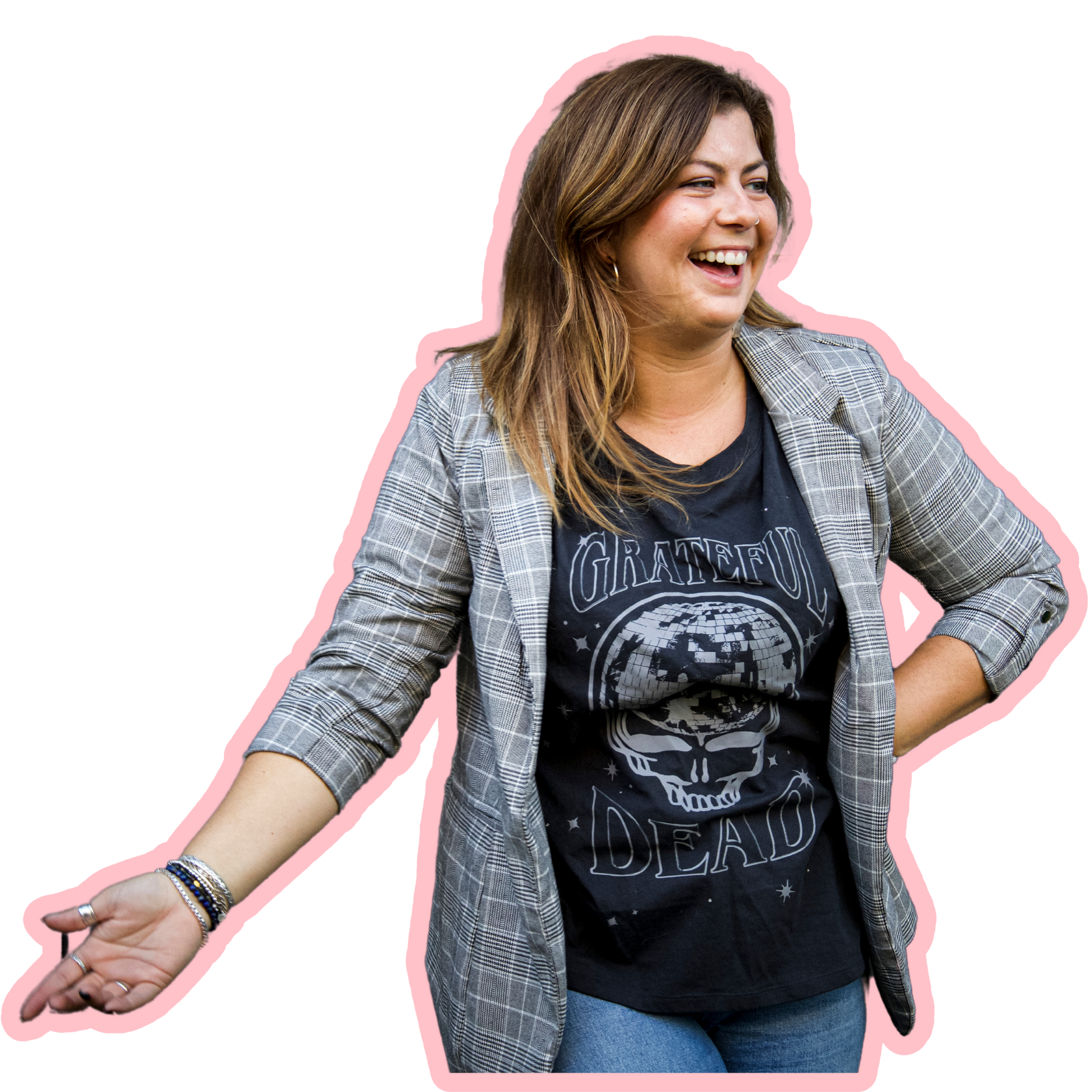 A woman smiling and gesturing outward, wearing a black Grateful Dead t-shirt and a plaid blazer, with her hair down.