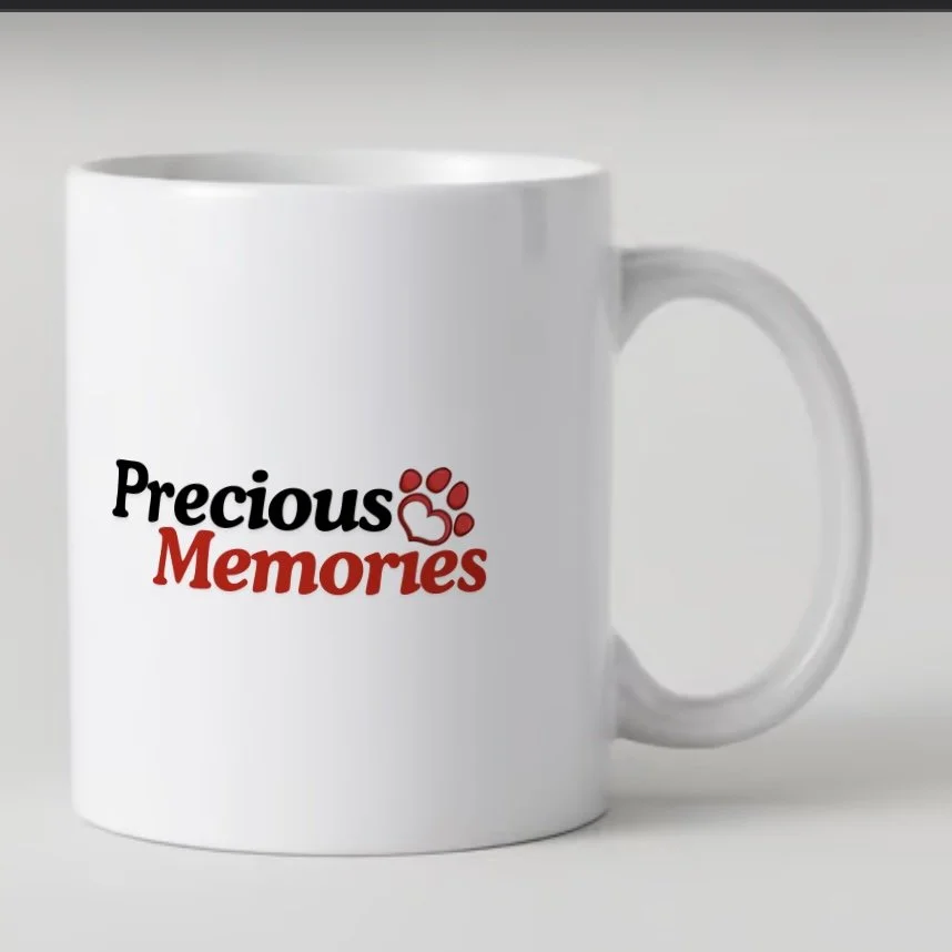 White coffee mug with 'Precious Memories' text and a paw print logo in black and red.