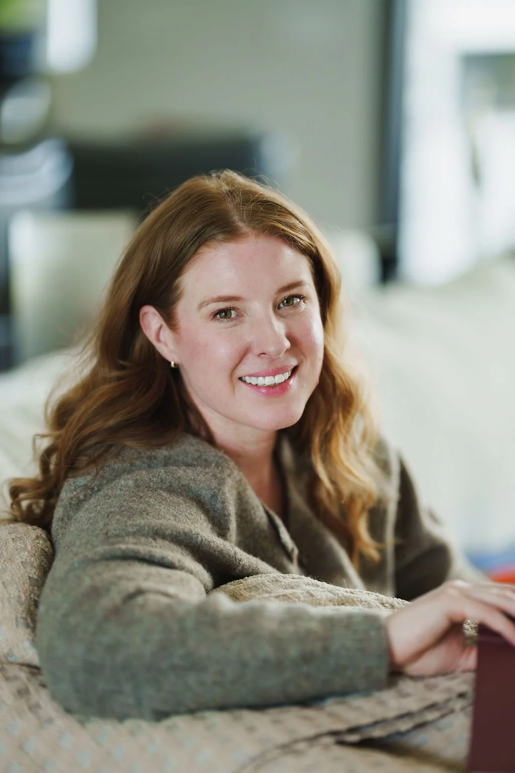 Nicole Lenkeit, trauma therapist and Pilates of pain and stress recovery in Sacramento CA, smiling in a warm therapy space.